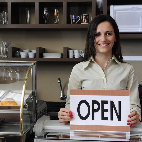 Happy Owner Of A Caf Showing Open Sign
