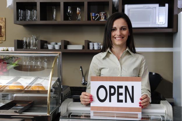 Happy Owner Of A Caf Showing Open Sign