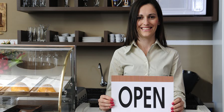 Happy Owner Of A Caf Showing Open Sign